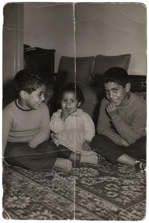 Before restoration: Three children behind a repaired fold